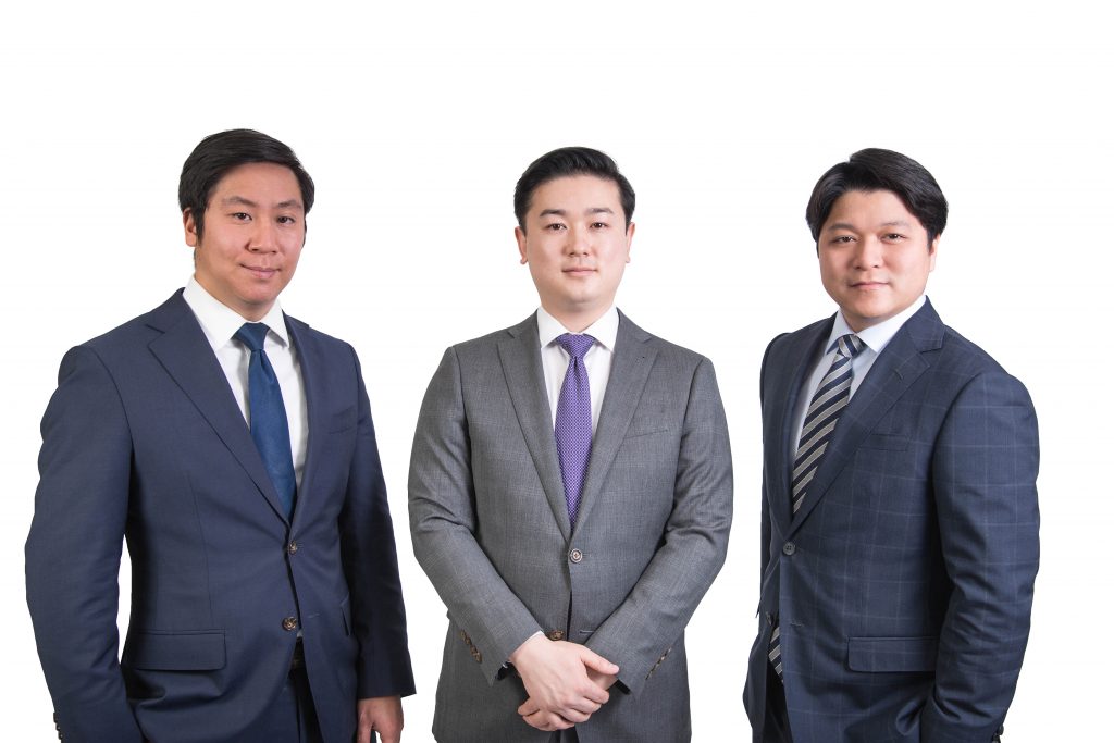Three professional Markham lawyers in suits standing shoulder-to-shoulder